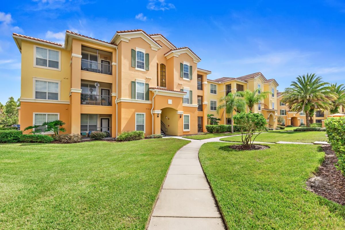 Alternate exterior view of orange apartment building in front of walk way