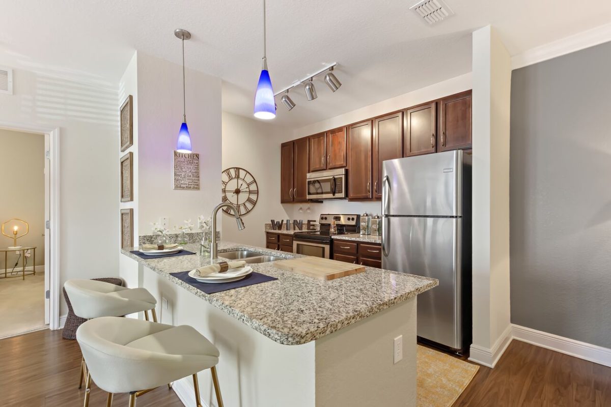 angled view of kitchen with counter and open area for guests to sit