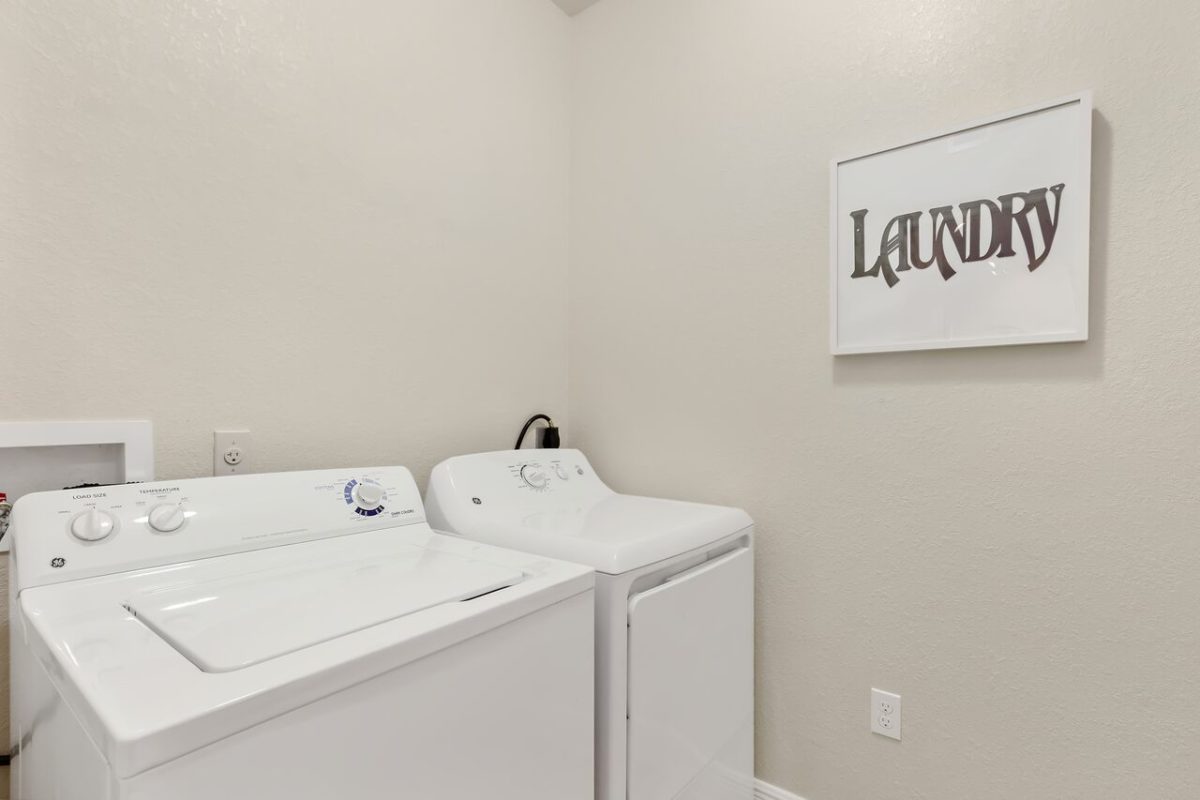 Washer and Dryer in front of picture with the word Laundry