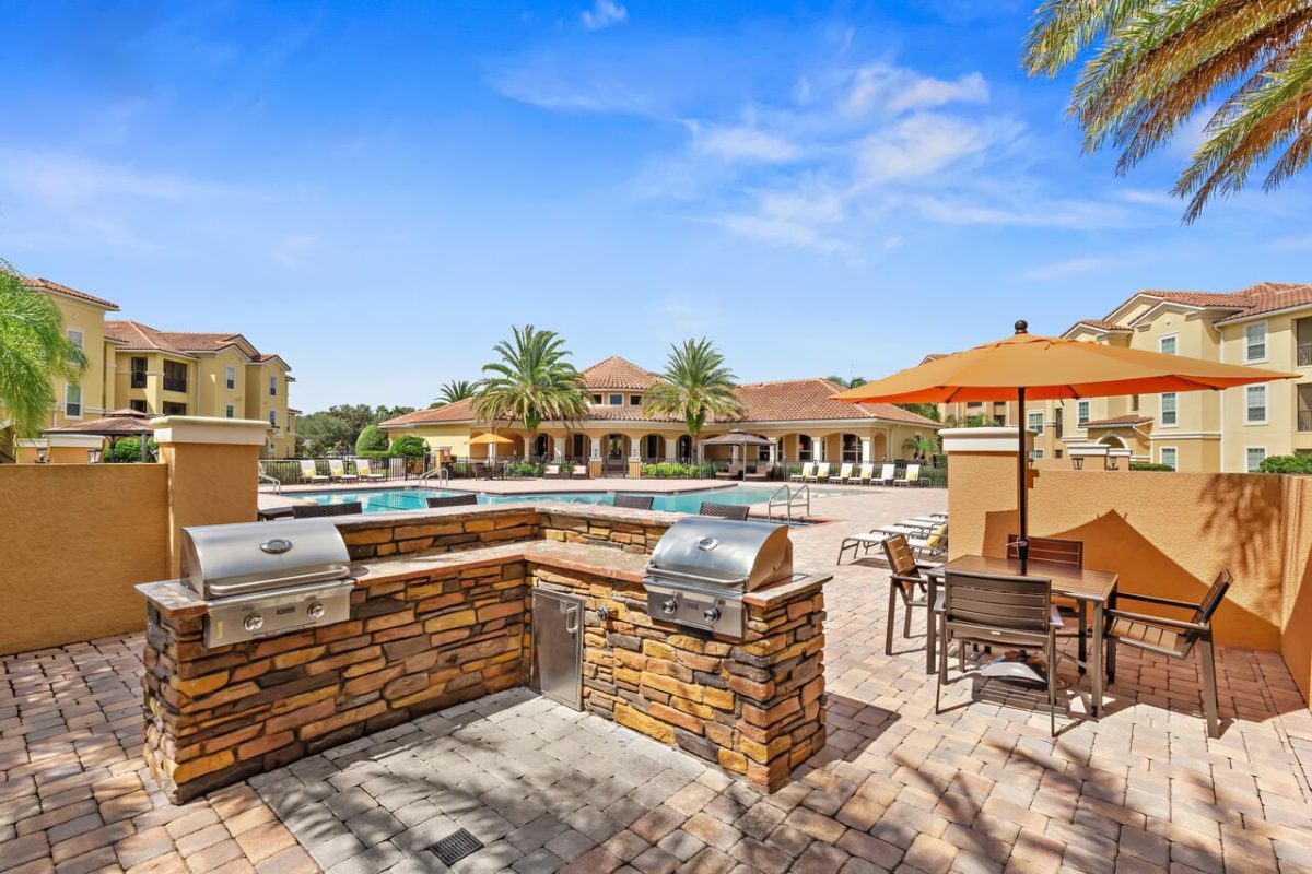 barbecue area inside of pool area, shaded seating in background